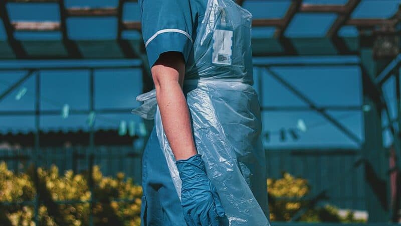 woman in blue and white polo shirt standing on yellow flower field during daytime