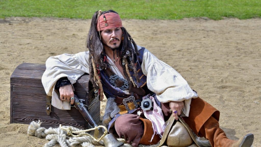 man in brown jacket and red cap sitting on brown horse during daytime